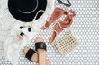 Flat lay fashion collage with women modern accessories on white mosaic tile. Slippers, hat, purse bag, perfume, earrings, sunglasses. Lifestyle, beauty concept for blog, social media, magazine.