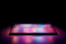 Half Open Laptop Computer Screen Reflecting Pastel Colorful Lights On The Keyboard On Black Background