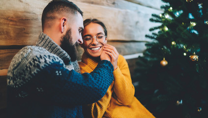 Wall Mural - Happy young couple laughing while celebrating Christmas