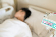 © arcyto - Close up IV set and blurry illness asian boy sleeping on hospital bed during treatment.Fluid intravenous drop saline set and blured young man is sick.Medical treatment concept.