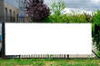 Leinwandbild Motiv Blank white advertising banner mounted on the fence against office building.