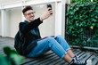 © GalakticDreamer - Student in glasses taking selfie while sitting on floor