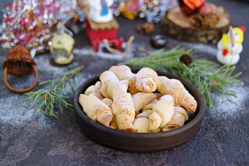 Wall Mural - Cottage cheese cookies in the shape of bagels in a brown ceramic bowl on a dark concrete background in the New Year and Christmas style. Recipes with cottage cheese.