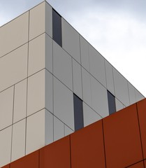 Wall Mural - Low angle shot of a modern white and orange building under the bright sky