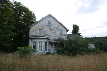 Wall Mural - Old abandoned historic farmhouse with broken windows and peeling paint