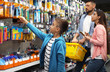 © New Africa - Family with little boy choosing school stationery in supermarket