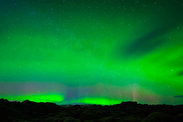 aurora borealis in night northern sky. ionization of air particles in the upper atmosphere.