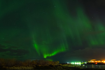 aurora borealis in night northern sky. ionization of air particles in the upper atmosphere.