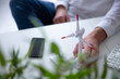 © Westend61 - Close-up of man with hand on wind turbine model on table