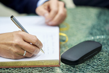 Close-up of a businessman hand signing a business contract book