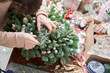 A woman decorates a Christmas arrangement. Master class on making decorative ornaments. Christmas decor with their own hands. The new year celebration. Flower shop