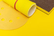Set of abrasive tools and sandpaper on yellow background