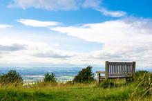 A Wooden Bench On The Cotswold Way Overlooking Cheltenham In Gloucestershire In Summer, England