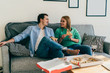 © GalakticDreamer - Couple eating pizza with red wine and relaxing on sofa at home