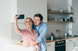 © GalakticDreamer - Loving couple taking self-photo in kitchen