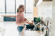 © GalakticDreamer - Young woman cooking standing in kitchen