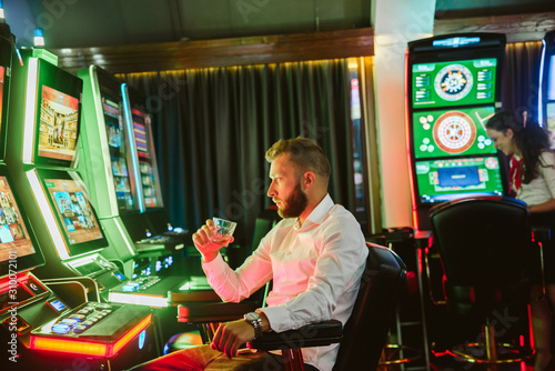 Cuadros en Lienzo Man playing a slot machine in a casino