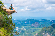 Beautiful Landscape, Nature Of Thailand. Young Traveler Sits On Rock That Overhangs Abyss, With A Beautiful Landscape Below. Dragon Crest (Khuan Sai) At Khao Ngon Nak Nature Trail In Krabi, Thailand
