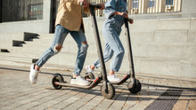 Lets Ride. Girl And Boy Having Fun Driving Electric Scooters On A Sunny Day