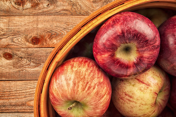 Wall Mural - Apples basket disposed on a wooden table. Flat lay, top view of autumn decoration concept.