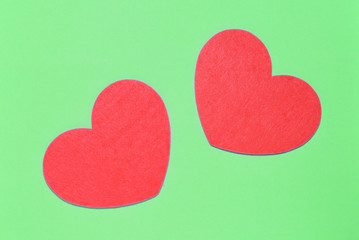 Two red hearts on a light green background closeup. Greeting card with copy space. Valentine's Day concept