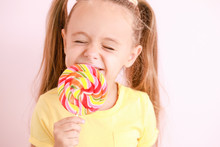 Cute Little Girl With Sweet Lollipop On Color Background