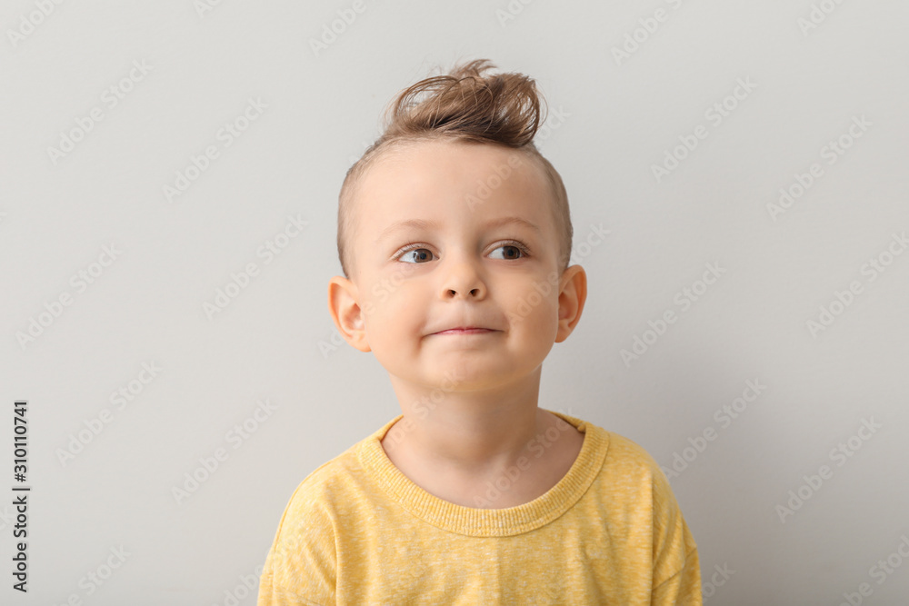 Portrait of cute little boy on light background