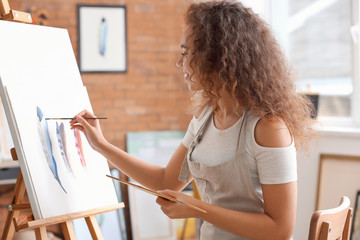 Wall Mural - Beautiful female African-American artist painting in studio