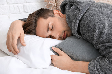 Sticker - Handsome man in bathrobe sleeping on bed