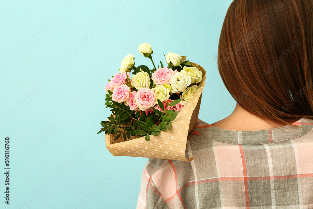 Female florist with beautiful bouquet on color background