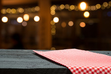 Empty Wooden Deck Table With Tablecloth Over Bokeh Background