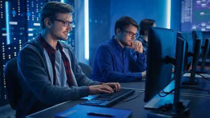 Fototapete - Team of Young IT Programers Working on Desktop Computers in Data Center System Control Room. Displays Show Concept: Software Development / Code Writing / Database Architecture. Technical Department