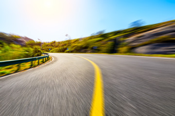 Blurred moving asphalt road and nature landscape during the day