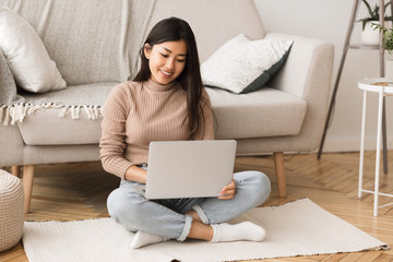 Poster - Young freelancer working on laptop, sitting on floor