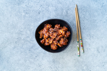 Asian Food Homemade Chinese General Tsos Chicken with Sesame Seeds served with Chopsticks.