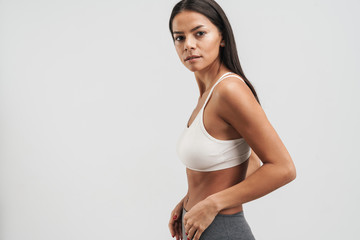 Wall Mural - Image of fitness woman in sportswear standing and looking at camera