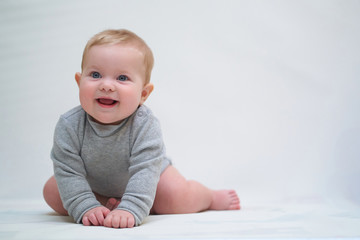 Wall Mural - a six-month-old baby learns to crawl. emotional portrait of a child