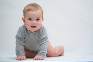 Wall Mural - a six-month-old baby learns to crawl. emotional portrait of a child