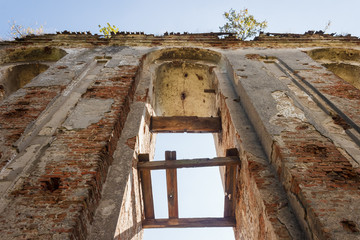 Old bell tower with arches of catholic church on blue sky background