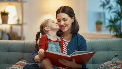 Wall Mural - mother reading a book to daughter