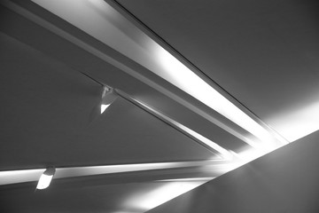 Poster - Double exposure of ceiling with backlit girders and spot lights. Abstract architecture fragment. Modern office building interior with polygonal white concrete elements. Diagonal geometric composition.