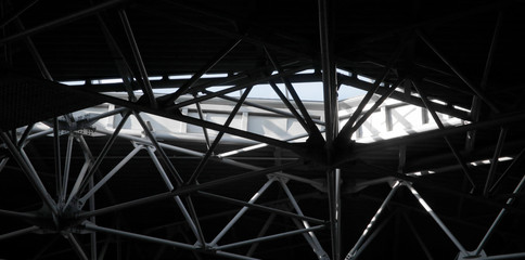 Poster - Close-up of industrial building interior fragment. Louvered metal surface and ceiling framework. Grunge abstract modern architecture image. Geometric structure of parallel and intersecting lines.