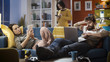 © StockPhotoPro - Friends connecting with their devices at home and ignoring each other