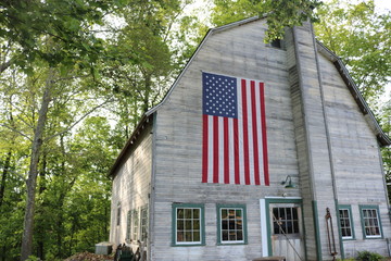 Old weathered wooden historic barn with American flag