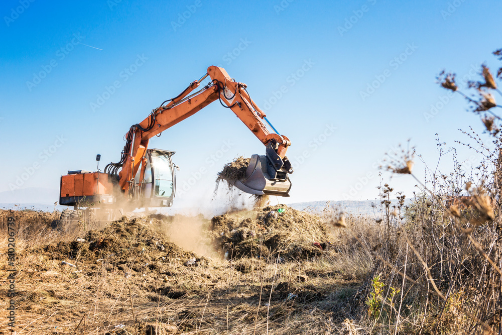 Excavator clears land for construction of a highway - obrazy, fototapety, plakaty 