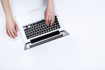 Poster - Female hands typing on laptop keyboard and using mouse on white background