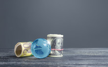 Money Bundle Rolls World Currencies And A Blue Glass Globe. Capital Investment, Savings. Profit Income, Dividends Payouts. Crowdfunding Startups Investing. Banking Service, Budget Monetary Policy