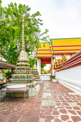 Wat Pho temple in Bangkok city, Thailand. View of pagoda and stupa in famous ancient temple. Religious buildings in buddhism style near Grand Palace. Oriental and Asian style, famous tourist target.