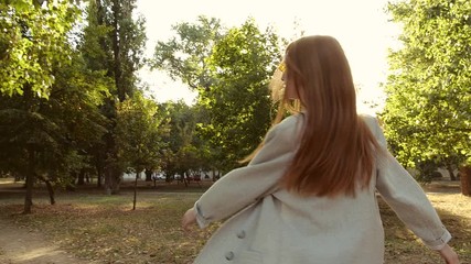 Poster - Beautiful young woman in park on sunny day. Slow motion effect