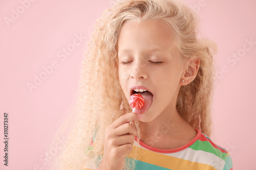 Cute little girl with lollipop on color background Poster Mural XXL